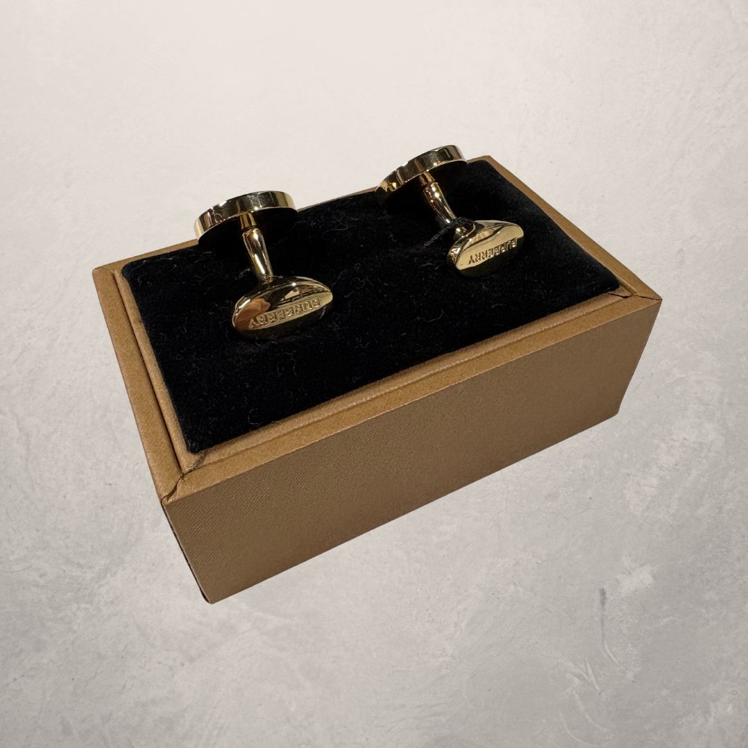Gouden manchetarmbanden van Burberry met doos.