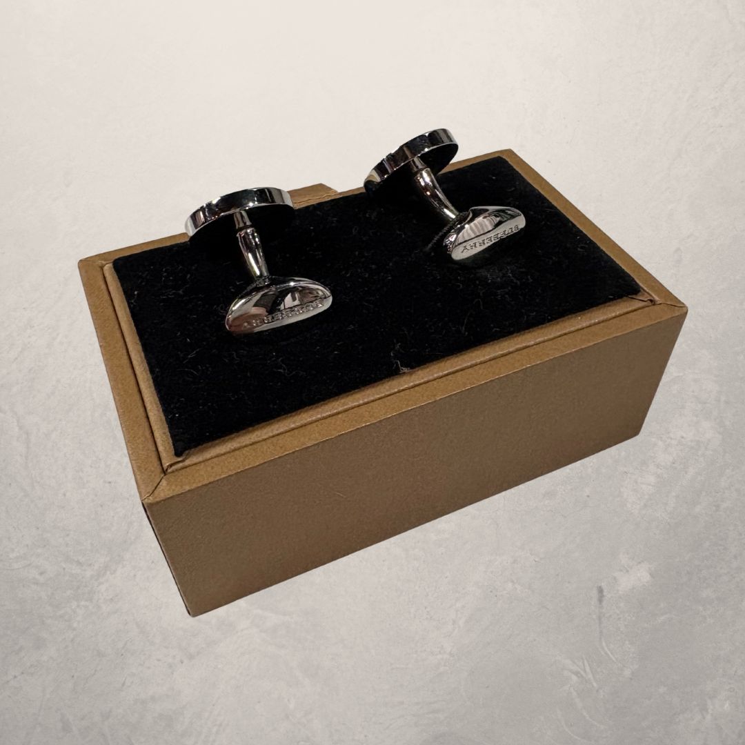 Zilveren manchetarmbanden van Burberry met doos.