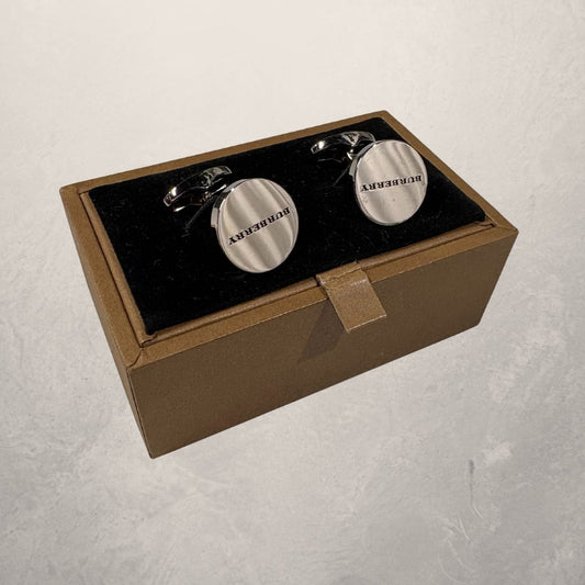 Zilveren manchetarmbanden van Burberry met doos.